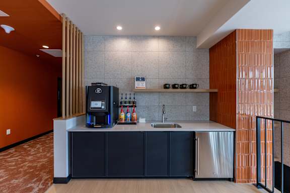 A modern kitchen with a black fridge and a sink.