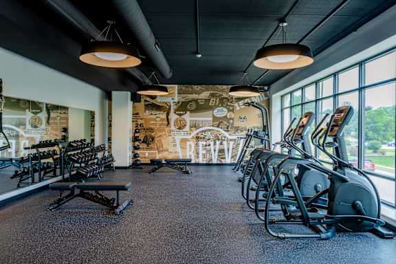 A gym with a variety of equipment including treadmills, weights, and exercise machines.