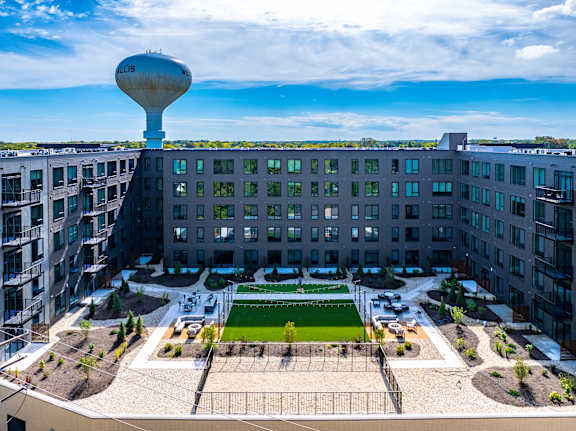 A large building with a water tower on top and a courtyard in the middle.