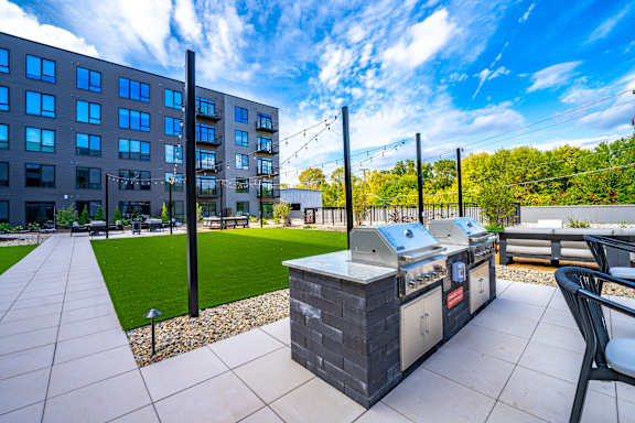 A modern outdoor kitchen area with a grill and seating area.