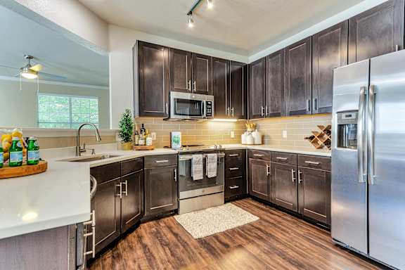 a kitchen with stainless steel appliances and wooden cabinets