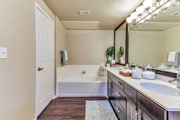 a bathroom with a tub and a sink and a mirror