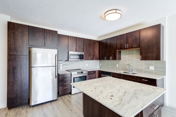 a kitchen with a marble counter top and wooden cabinets