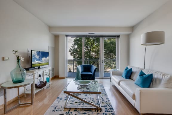 a living room with a white couch and a large window at Verge Apartments in St. Louis Park, MN