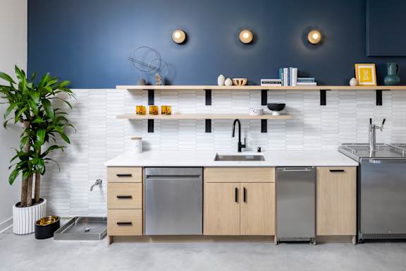 A modern kitchen with a white countertop and stainless steel appliances.