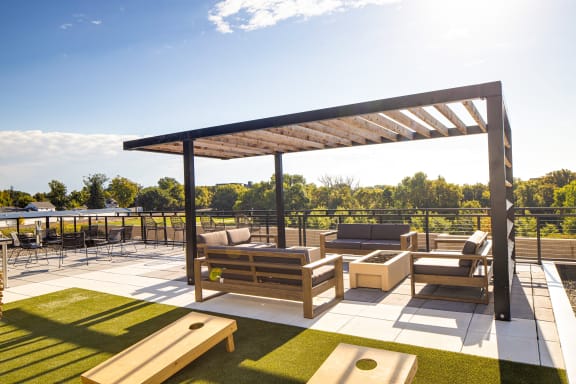 a rooftop patio with lounge furniture and a pergola at Riverhouse Apartments, Fargo, North Dakota 58102