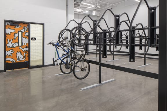 A bike rack with several bikes on it and a door with a mural on it  at Kesler Apartments, Fargo, North Dakota 58102