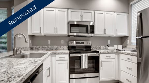 a kitchen with white cabinets and granite counter tops