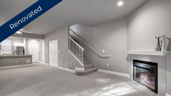 a living room with a fireplace and a staircase
