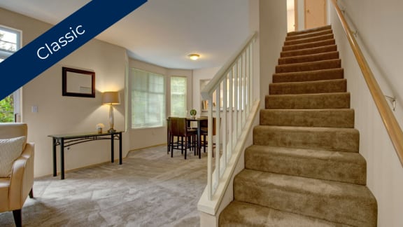 a home with carpeted stairs and a dining room with a table and chairs