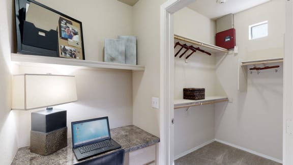 a laptop on a desk in a room with a walk in closet