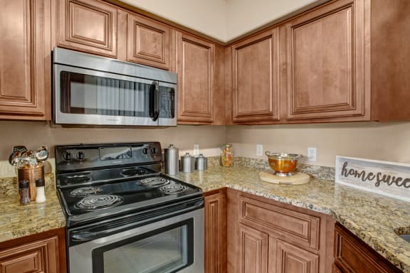 a kitchen with wooden cabinets and a stainless steel microwave