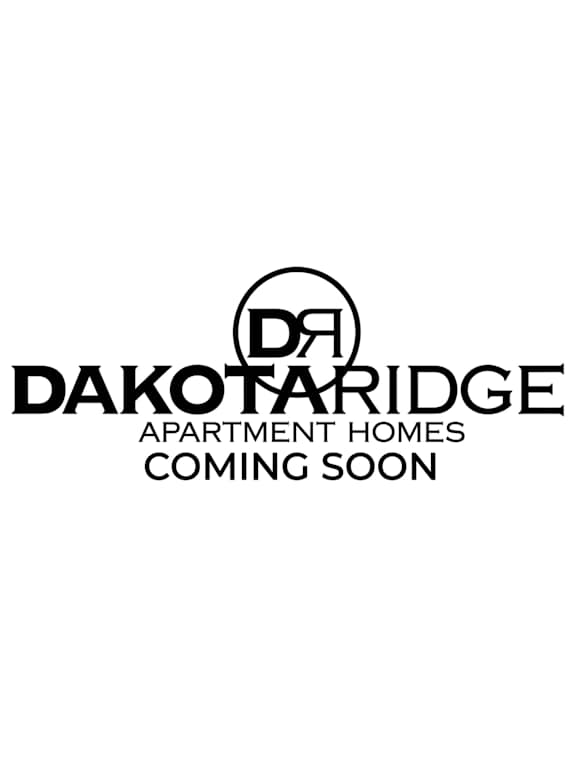 A black and white image of a sign that says Dakota Ridge Apartment Homes Coming Soon.