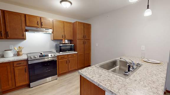 A kitchen with wooden cabinets and a granite countertop.