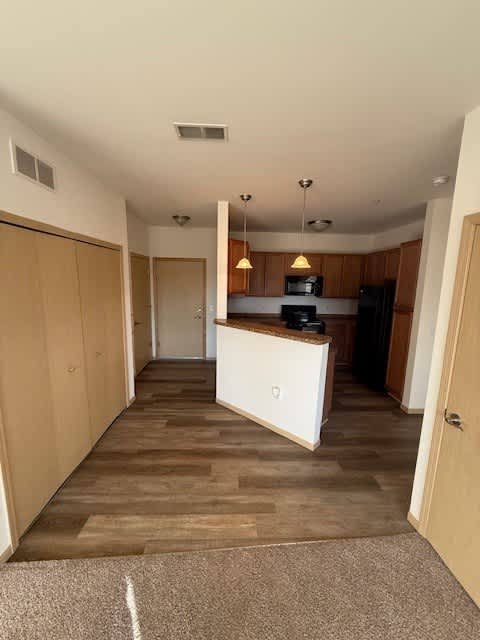 A kitchen area with a white counter and brown cabinets.