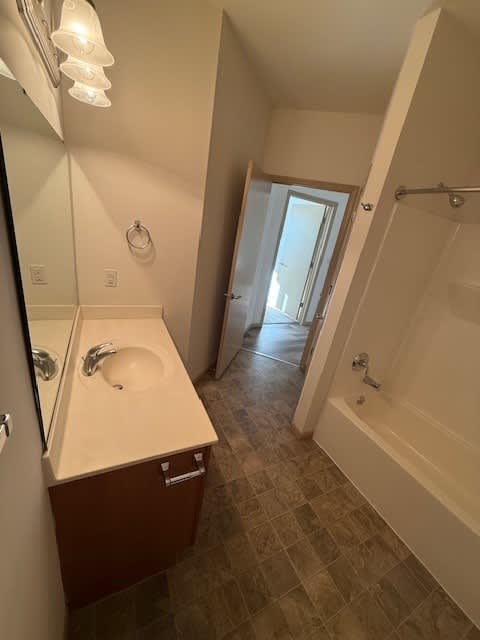 A bathroom with a sink, mirror, and tiled floor.