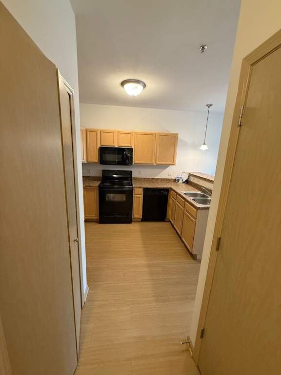 A kitchen with wooden cabinets and appliances.
