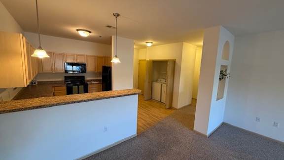 A living room with a kitchen area in the background.
