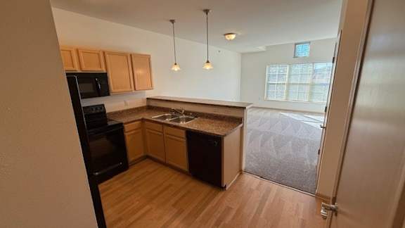 A kitchen with wooden cabinets and a black oven.