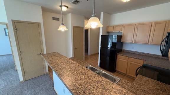 A kitchen with granite countertops and wooden cabinets.
