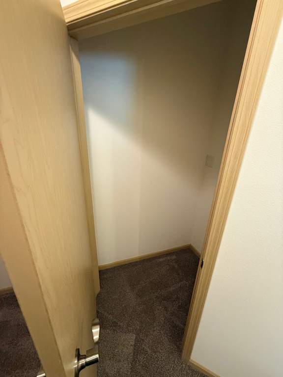 A small, dark room with a wooden door.
