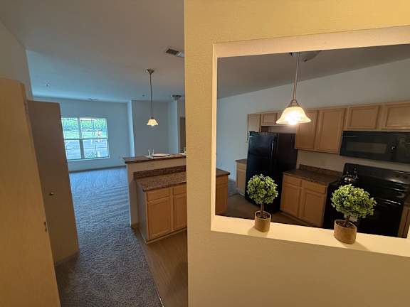 A kitchen with a refrigerator, microwave, and oven.
