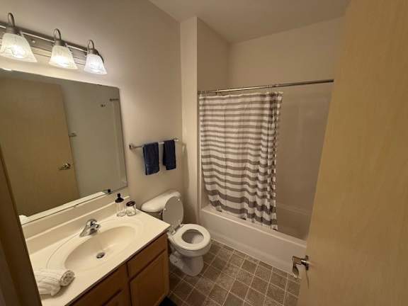 A bathroom with a toilet, sink, and shower.