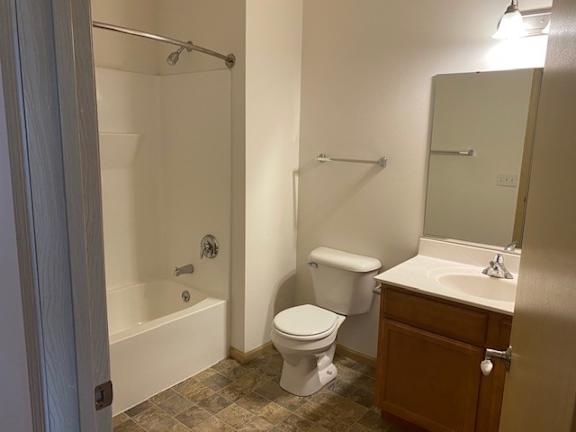 A white toilet sits next to a sink in a bathroom.