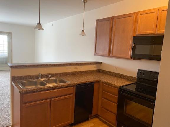 A kitchen with brown cabinets and a black stove.