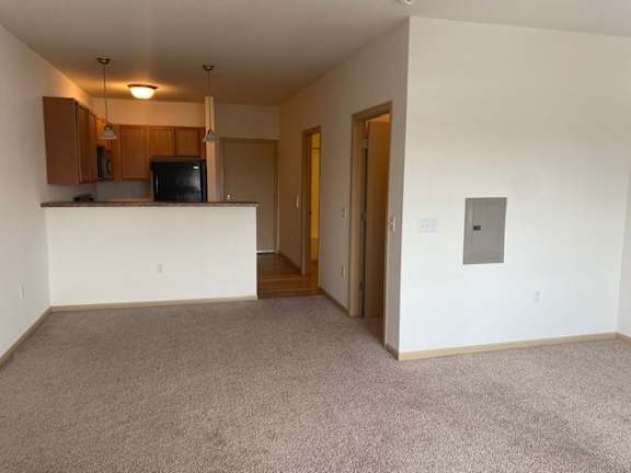 A room with a carpeted floor and a white counter.