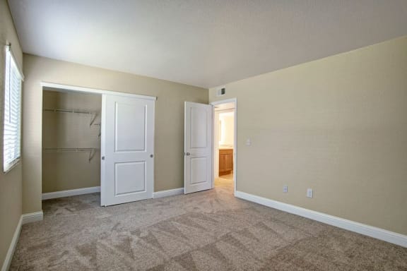 a bedroom with two doors and a closet