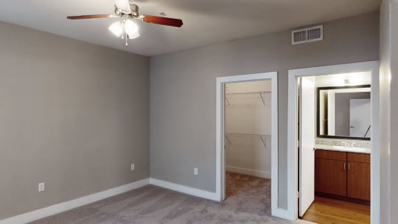 a bedroom with a ceiling fan and a mirror