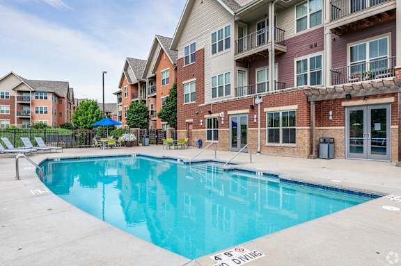 A swimming pool in front of apartment buildings.