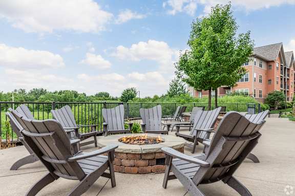 A patio with chairs and a fire pit.