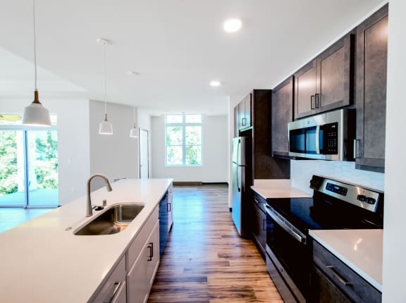 a kitchen with a sink stove refrigerator and microwave