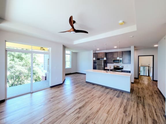 an open living room and kitchen area with a ceiling fan