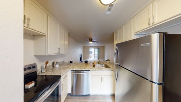 a kitchen with white cabinets and stainless steel appliances