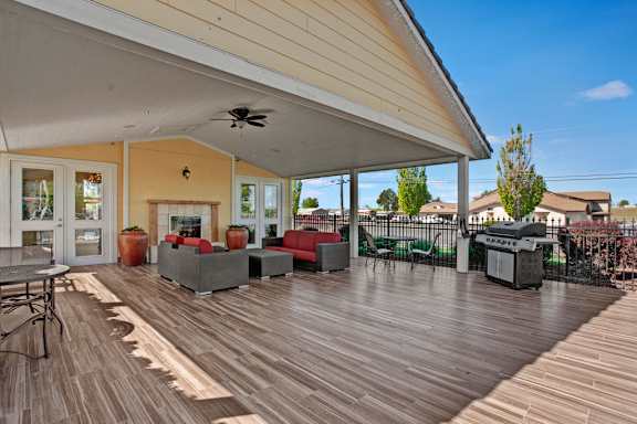 A wooden deck with a table and chairs is in the foreground.