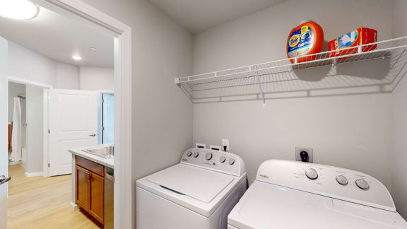 a laundry room with two washers and a dryer