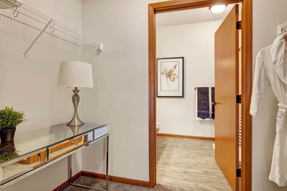 a room with a mirror and a glass table with a lamp on it
