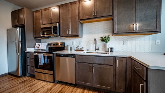 a kitchen with wooden cabinets and a stainless steel refrigerator