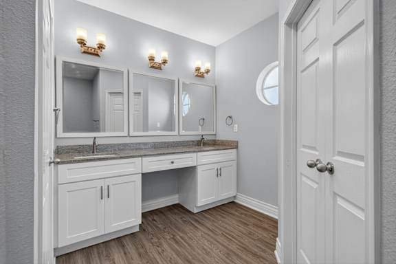 A bathroom with a vanity and a mirror above it.