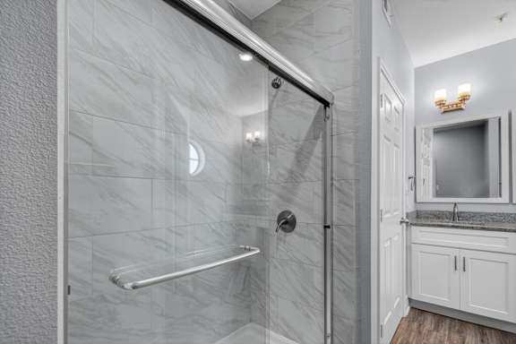 A modern bathroom with a walk-in shower and a separate sink area.