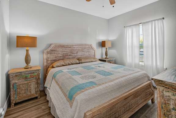 A bedroom with a large bed and two lamps.