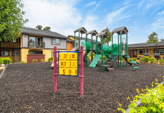 A playground with a sign that says "Kids Play Area" in front of a building.