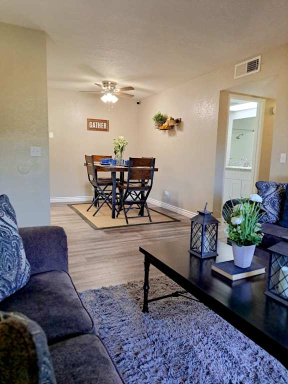 A living room with a dining table and chairs at Raintree Apartments, Highland, CA