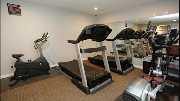 The gym at Bella Park with a treadmill, elliptical trainer, and other exercise equipment.