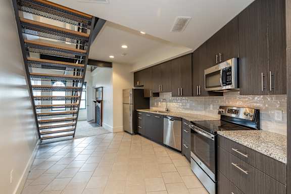 a kitchen with stainless steel appliances and a spiral staircase
