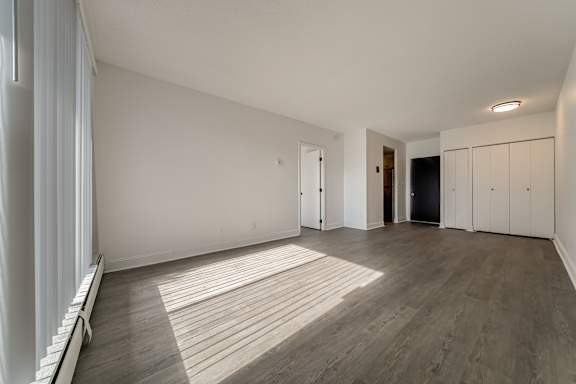 A room with wooden flooring and white walls.