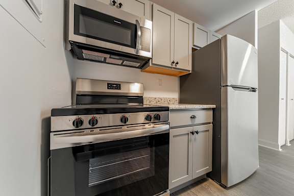 A modern kitchen with a stove, oven, microwave, and refrigerator.
